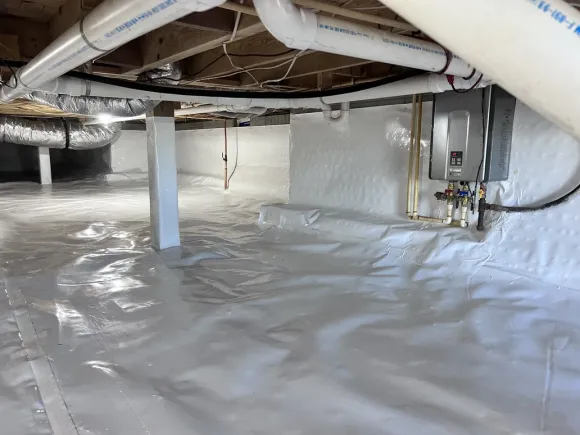 Crawlspace fully sealed with a white vapor barrier over the floor and walls